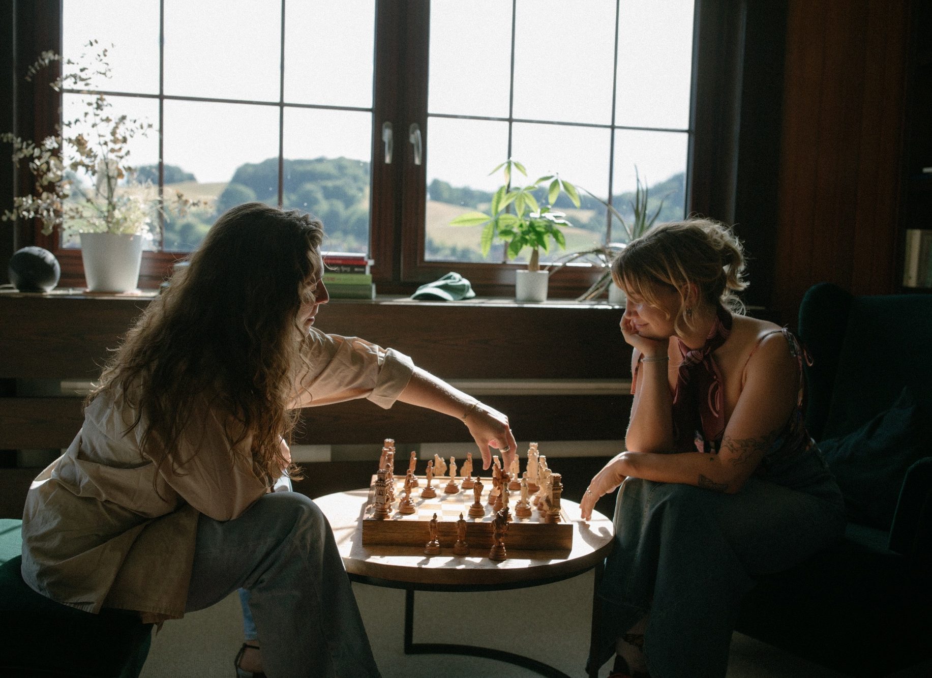 Lotta und Lisa spielen Schach – Lisa zieht gerade einen Stein. Lotta Falter und Lisa Schubert sitzen vor einem Schachbrett, Lisa macht gerade ihren Zug.